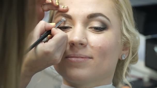 Makeupartist gör en flicka vacker makeup innan en viktig händelse — Stockvideo