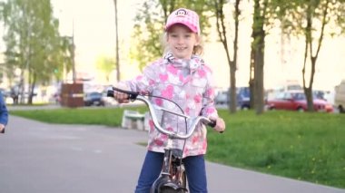Küçük kız Bisiklete binme, küçük çocuk parkında bir scooter sürme.