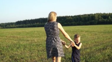 Anne ile oğlu alan günbatımında çalış. Yavaş mo