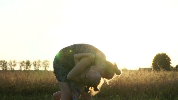 Mamma spelar med dotter på fältet vid solnedgången. Långsamma mo — Stockvideo