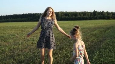 Anne ile kızı günbatımında sahasında oynuyor. Yavaş mo