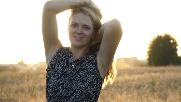 Schoonheid romantische jonge vrouw buitenshuis. Mooi model meisje in jurk op het veld in zonlicht. Vrolijke jonge vrouw die ter plaatse in het veld dwarrelen bij zonsondergang. — Stockvideo