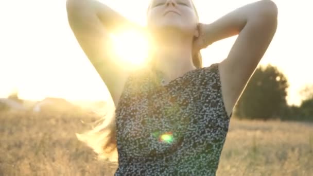 Schoonheid romantische jonge vrouw buitenshuis. Mooi model meisje in jurk op het veld in zonlicht. Vrolijke jonge vrouw die ter plaatse in het veld dwarrelen bij zonsondergang. — Stockvideo