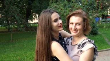 Portre portre yetişkin kızı ve anne açık havada. Güzel esmer ve Her anne parkta kameraya yaz aylarında arıyoruz.