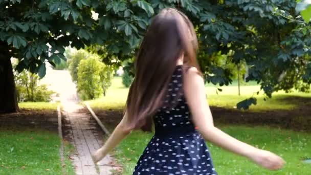 Young, beautiful, attractive woman in a stylish dress, posing on camera. She laughs, poses for the camera, her hair blowing in the wind, looking very happy. slow motion — Stock Video