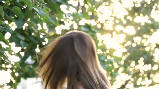 Jovem menina sorrindo torções cabeça e seu cabelo voar para longe em câmera lenta — Vídeo de Stock