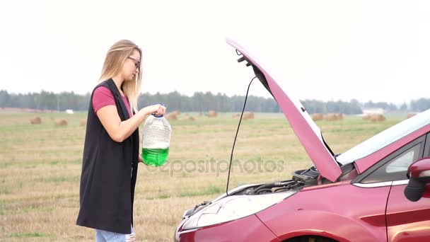 Chica vierte anticongelante en su coche en la carretera — Vídeos de Stock