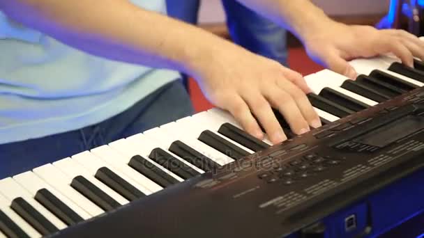 Piano elétrico, Ator tocando no teclado sintetizador teclas de piano. O músico toca um instrumento musical no palco do concerto. sintetizador, pressione as teclas, homem, artista, nota — Vídeo de Stock