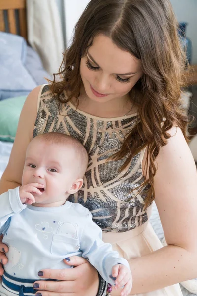 Close-up portrait of happy young mother hugging and kissing his sweet adorable child. Indoors shot, concept image — Stock Photo, Image