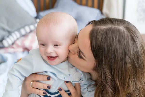 Close-up portret szczęśliwy młoda matka, przytulanie i całując jego słodka urocza dziecko. Pomieszczeniu strzał, koncepcja obraz — Zdjęcie stockowe