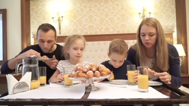 Otel odasında kahvaltı yapan mutlu bir aile. — Stok video