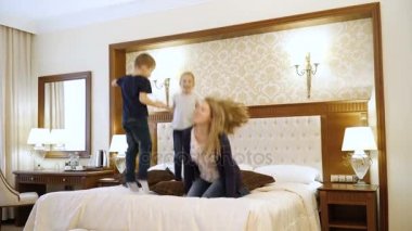 Sahne gösterir genç Aile Oda atlama. Anne, baba ve çocuk Avrupa görünüm. Mutlu aile hayatı, başarı, eğlence, reklam otel veya yatak çarşafları kavramı