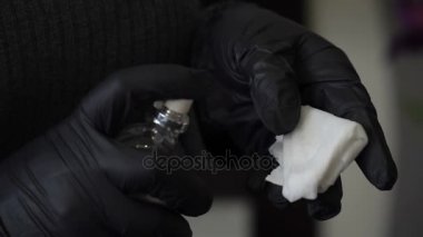 Kalıcı makyaj uzmanı dezenfeksiyon için sıvı bir peçeteye spreyler. cilt bakım kumaş