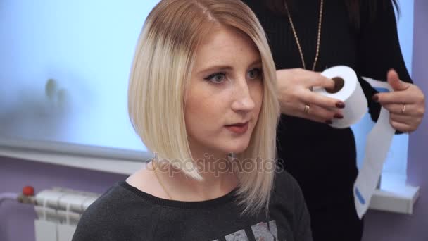 Vorbereitung einer Blondine auf einen Haarschnitt. Frau bekommt neue Frisur vom Friseur im Schönheitssalon. Haare polieren — Stockvideo