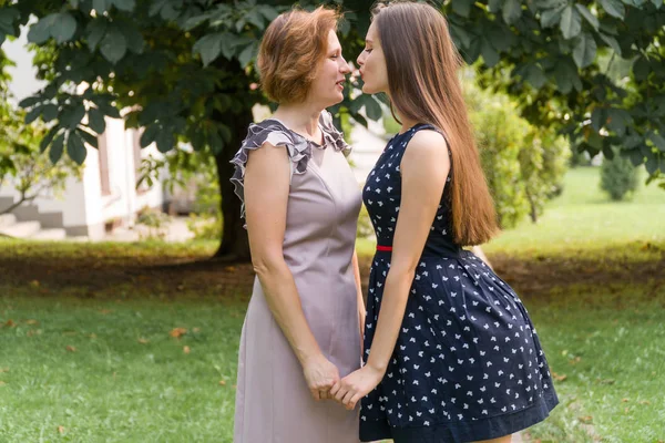 Portre portre yetişkin kızı ve anne açık havada. Güzel esmer ve Her anne parkta kameraya yaz aylarında arıyoruz.
