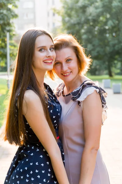 Detailní portrét dospělá Dcera a matka venku. Hezká brunetka a její maminka se při pohledu na fotoaparát v parku v létě. — Stock fotografie