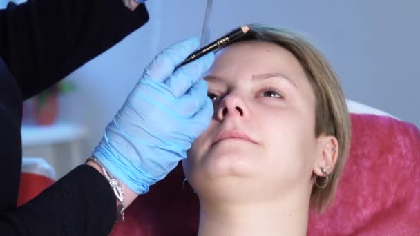 Un colpo ravvicinato. Specialista professionista del trucco permanente che applica l'eyeliner del sopracciglio prima della procedura. Bellezza, trucco e concetto di moda — Video Stock