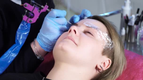 Estetista, specialista del trucco permanente sta applicando l'anestetico locale prima della procedura permanente di trucco delle sopracciglia. primo piano . — Video Stock