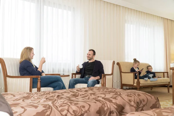 남편과 아내와 호텔 방에 아이 들 어린이 자에 부모는 침대에 앉아 있다. 젊은 가족은 매우 행복 스톡 이미지