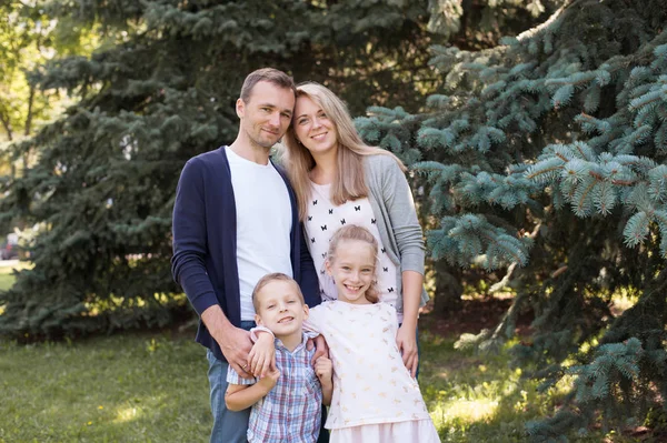 Mama i tata, grając z ich przystojny syn i córka - Rodzina i dzieci na zewnątrz park - młode piękne rodziny pozowanie dla fotografa — Zdjęcie stockowe