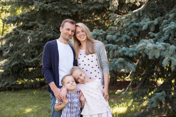 Mama i tata, grając z ich przystojny syn i córka - Rodzina i dzieci na zewnątrz park - młode piękne rodziny pozowanie dla fotografa — Zdjęcie stockowe