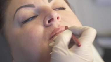 Atış kapatın. Kalıcı makyaj uygulayarak dudak prosedürü önce profesyonel uzman. Güzellik, makyaj ve moda kavramı