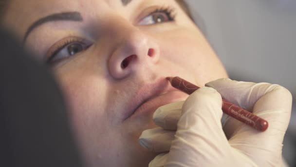 Atış kapatın. Kalıcı makyaj uygulayarak dudak prosedürü önce profesyonel uzman. Güzellik, makyaj ve moda kavramı — Stok video