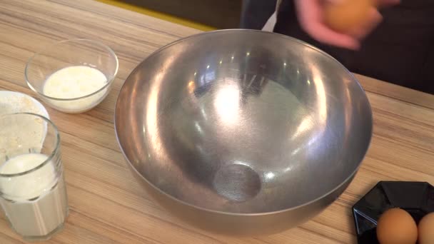 Laga mat. Färska ekologiska ägg hamnar i skålen. Livsmedelsingrediens. Äggula faller i metall skål. Bakning ingredienser. — Stockvideo