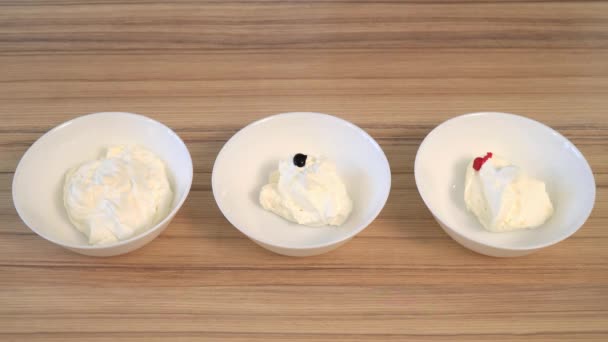 Vue du dessus du mélange de la crème pour décorer et teindre dans le bol. Cuisson des cupcakes . — Video
