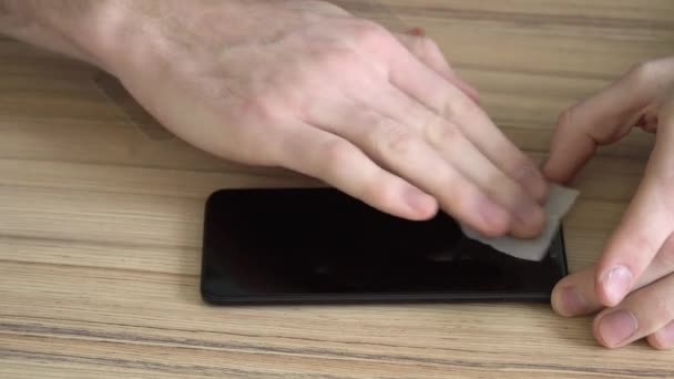 Gros plan. Préparation de l'écran pour un nouveau téléphone mobile. Nettoyage avec un chiffon humide. Nouveau verre protecteur, haché, antichoc .