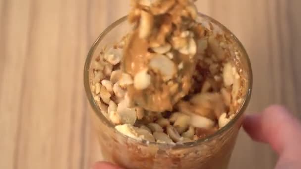 Ovanifrån att blanda grädde för dekoration i en skål. Kokt kondenserad mjölk och jordnötter — Stockvideo