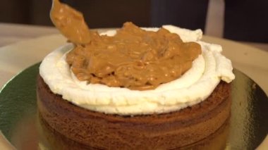 Kek. Brownie. Tatlılar. Tereyağı krema konfeksiyon üzerinde Close-Up. Çikolatalı pasta üzerinde beyaz yumuşak krema. Yakın: hassas krem pasta çantaya. Pasta krem kek dekore edilmiştir. Sünger kek.