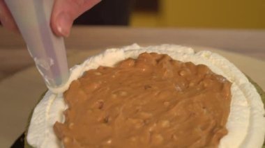 Kek. Brownie. Tatlılar. Tereyağı krema konfeksiyon üzerinde Close-Up. Çikolatalı pasta üzerinde beyaz yumuşak krema. Yakın: hassas krem pasta çantaya. Pasta krem kek dekore edilmiştir. Sünger kek.