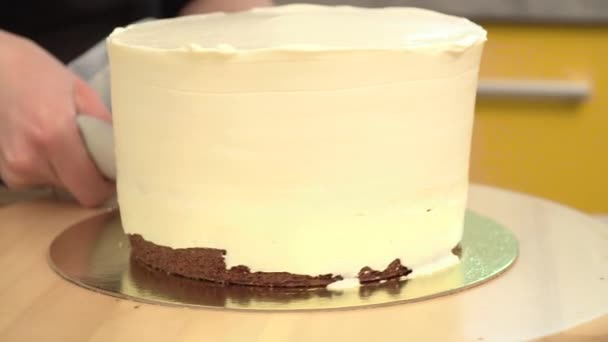 Γκρο πλαν: κρέμα με τη μορφή μιας σπείρας στην τούρτα μπισκότο. Παντεσπάνι σοκολάτας με κρέμα. Το φαγητό για τις διακοπές. Προετοιμασία του κέικ σε ένα κατάστημα καραμελών. — Αρχείο Βίντεο