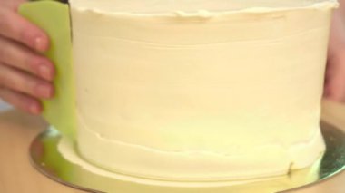 Yakın çekim: bisküvi kremalı kek üzerine bir spiral şeklinde. Çikolatalı krema ile sünger kek. Tatil için yiyecek. Bir şekerci dükkânı pastada hazırlanması.