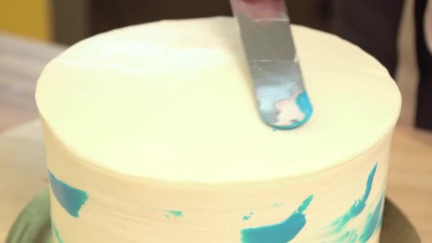 Nahaufnahme: Kekscreme in Form einer Spirale auf dem Kuchen. Schokoladenbiskuit mit Sahne. das Essen für den Urlaub. Zubereitung von Kuchen im Süßwarenladen. — Stockvideo