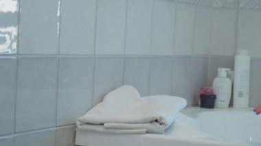 Bir kadının el havlu alır. havlu üzerinde lavabo aittir
