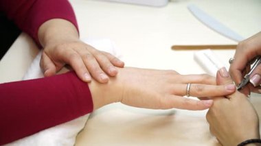 Bir kadının tırnakları kesilmiş ve onun manikür için boyalı tırnakları Başlarken önce temizlenmiş alır. Makasları ile manikür