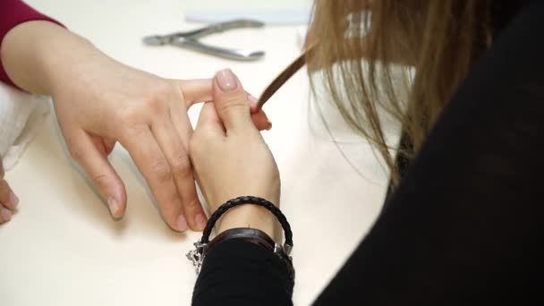 Крупный план женщины в маникюре, получающей маникюр от косметолога с пилкой для ногтей. Женщине делают маникюр. Мбаппе придирается к клиенту — стоковое видео