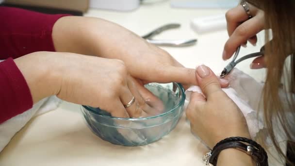 Eine Frau lässt sich ihre Nägel schneiden und reinigen, bevor sie sich ihre Nägel für ihre Maniküre lackieren lässt. Maniküre mit Haarschneidemaschine — Stockvideo