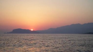 Güzel, romantik günbatımı yakınındaki bulutlar dalgalar ile