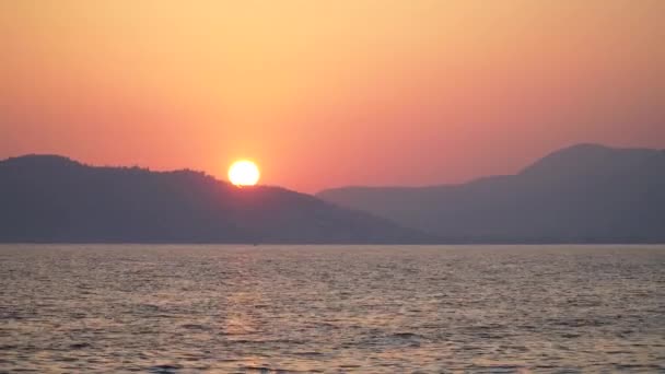 Schöner, romantischer Sonnenuntergang mit Wellen in der Nähe der Berge — Stockvideo