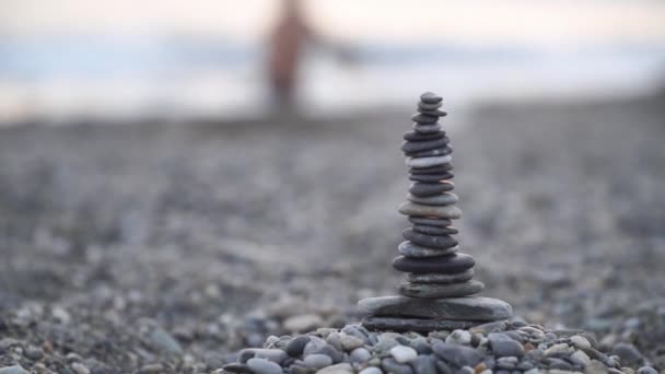 Η εξισορρόπηση πέτρινο πύργο στην παραλία της θάλασσας με τα κύματα — Αρχείο Βίντεο