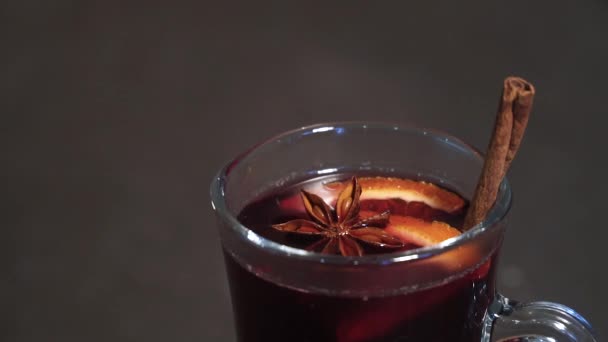 Hot red wine with fruits and spices in a glass. mulled wine. Slow-mo — Stock Video