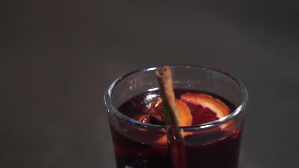 Hot red wine with fruits and spices in a glass. mulled wine. Slow-mo — Stock Video