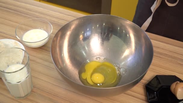 Cooking food. Fresh organic eggs falling into bowl. Food ingredient. Egg yolk falling in metal bowl. Baking ingredients. — Stock Video