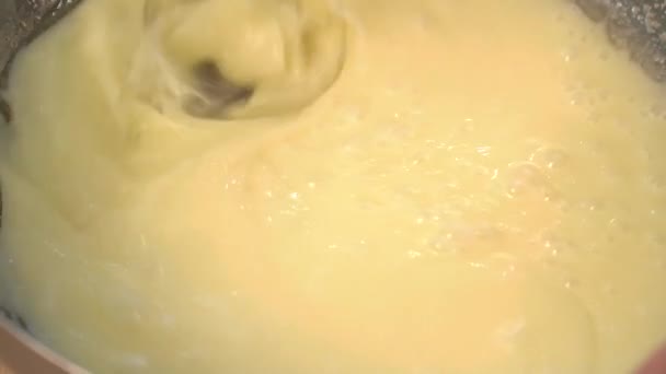 Кондитер быстро смешивает яичный желток и сахар в металлическую миску — стоковое видео