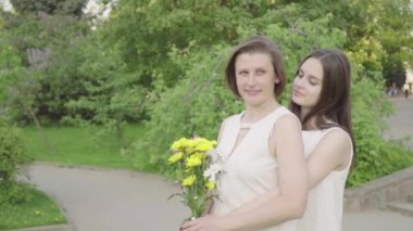 Toplantı kızı ve annesi parkta. Her anne sarılma sevgi ve hassasiyet ile çekici esmer olduğunu