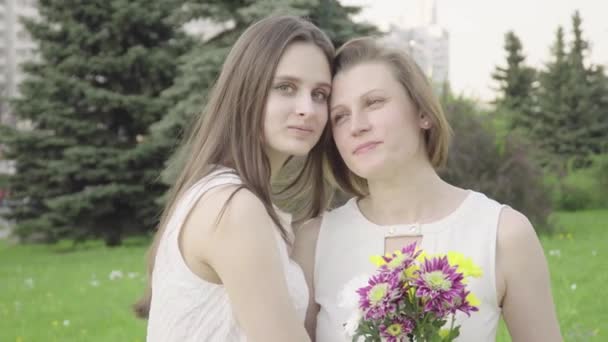 Vergadering dochter en haar moeder in het Park. Aantrekkelijke Brunette is knuffelen Hare moeder met liefde en tederheid — Stockvideo