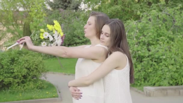 Incontro con sua figlia e sua madre nel parco. Attraente bruna sta abbracciando sua madre con amore e tenerezza — Video Stock